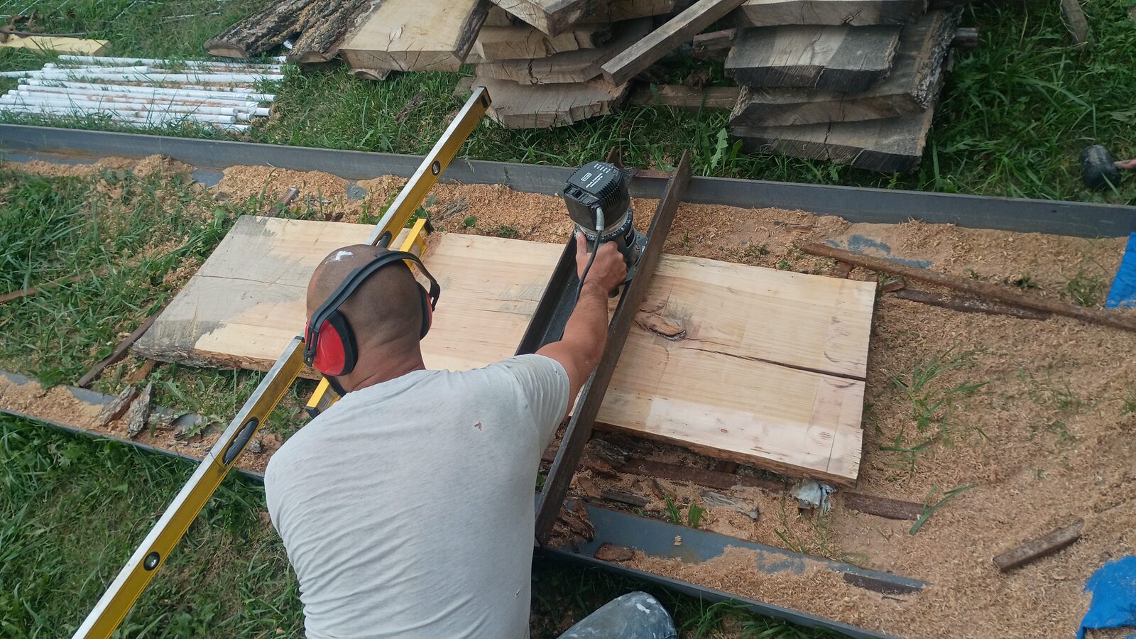 Overhead view of the planing setup with lumber stacks in the background