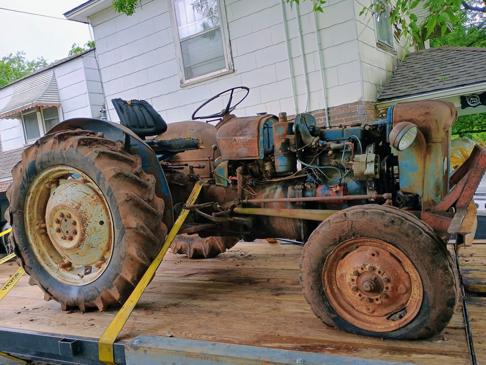 Side profile — old Ford on the flatbed, strapped down