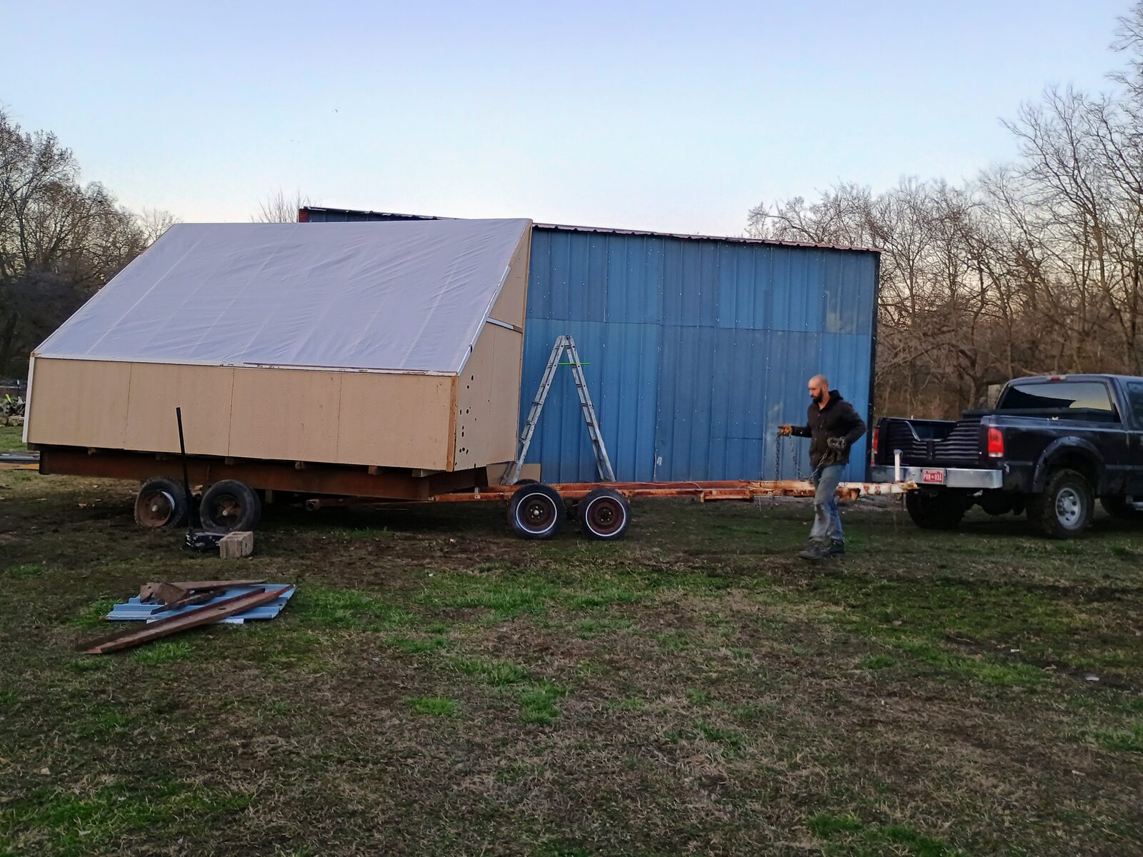 Wide shot of the completed kiln next to the blue shop building