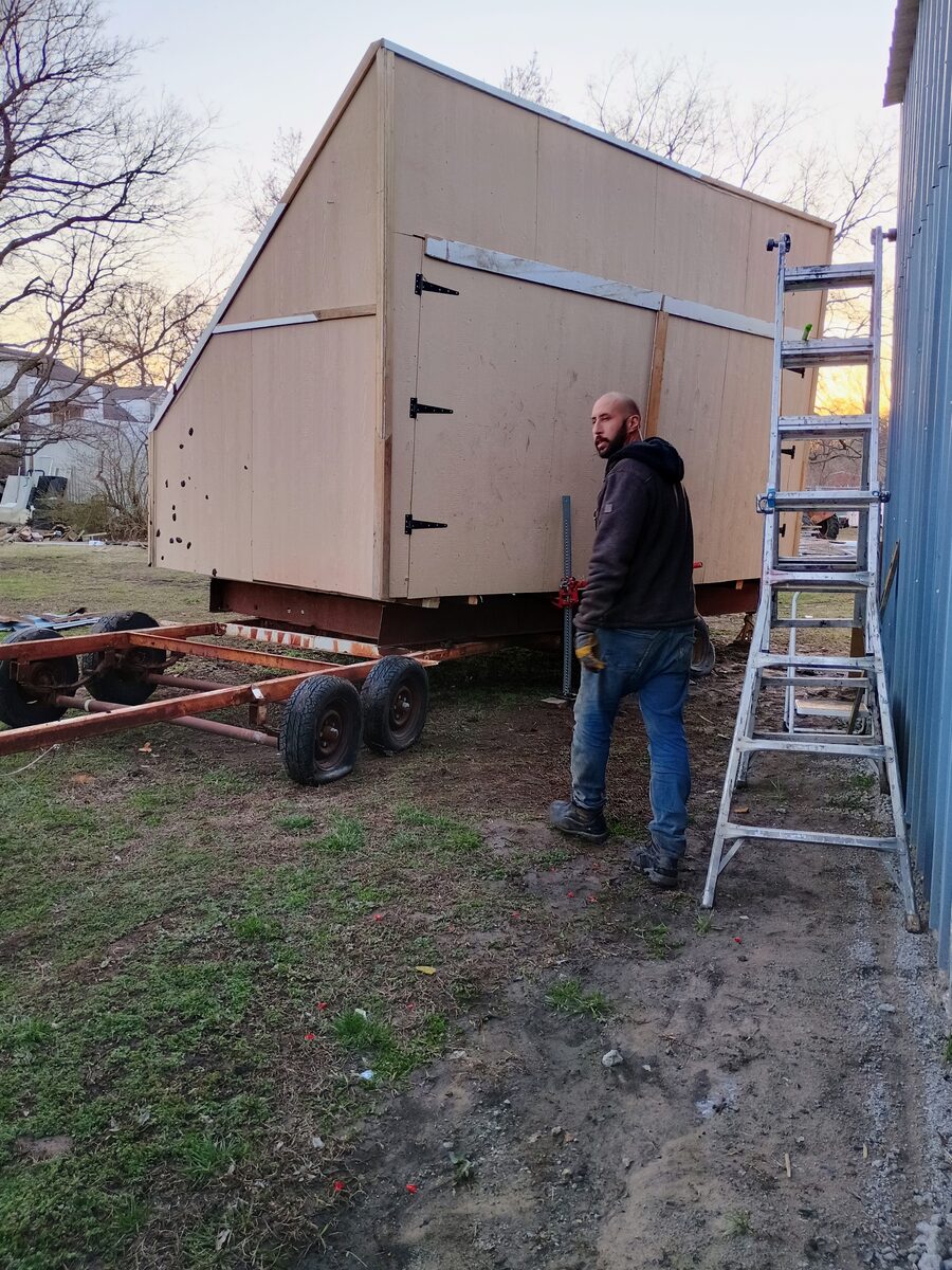 Kiln sheathed in plywood with strap hinges on the doors — translucent roof panels installed